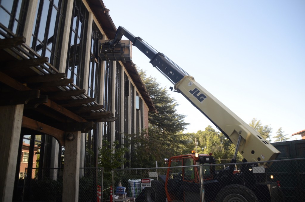 Construction workers use a cherry picker to lift dry wall to the third floor of Rodda North as construction on the building continues. Christopher Williams | Staff Photographer