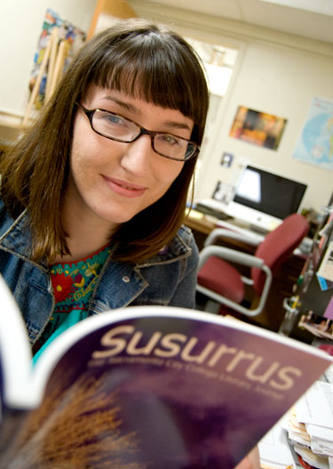 Cristina Preda sits in front of various issues of Susurrus journals on Feb. 25 in the Express office. Photo by Robert Paul.
