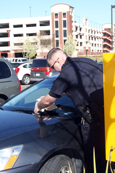 City College Police Officer John Corcoran patrols the staff parking lots and tickets illegally parked student vehicles. Photo by Windee Dawson 