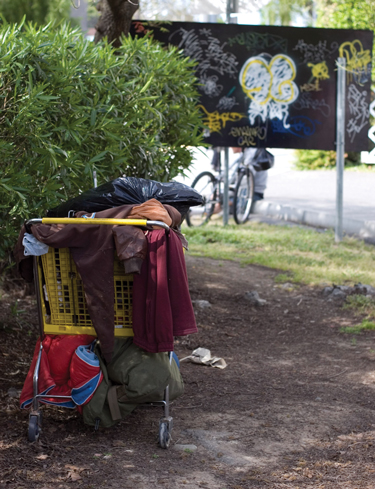 A homeless man hides his belongings on