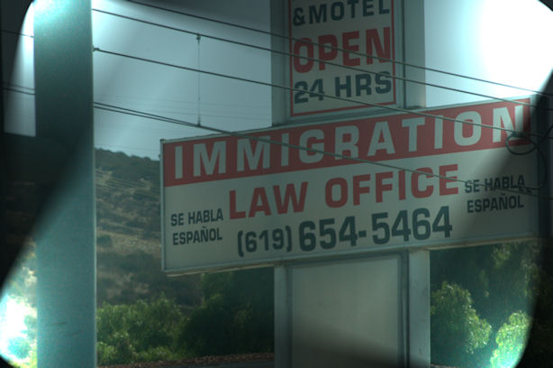 An immigration office sign with a phone number.