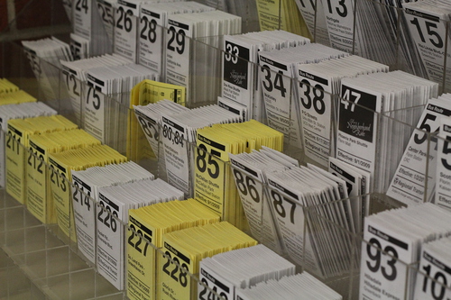 Printed white and yellow Sacramento lightrail schedules placed in rows.