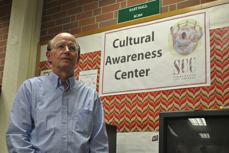 A man standing in front of the Cultural Awareness Center sign.