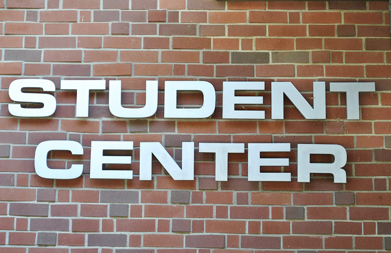 A sign of the Student Center on a brick wall.