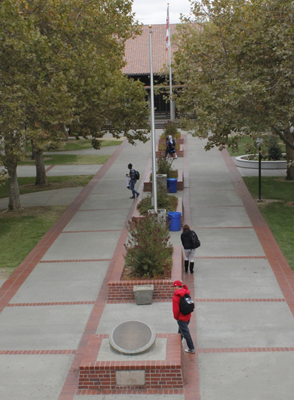 A handfull of students walk through an almost empty quad.