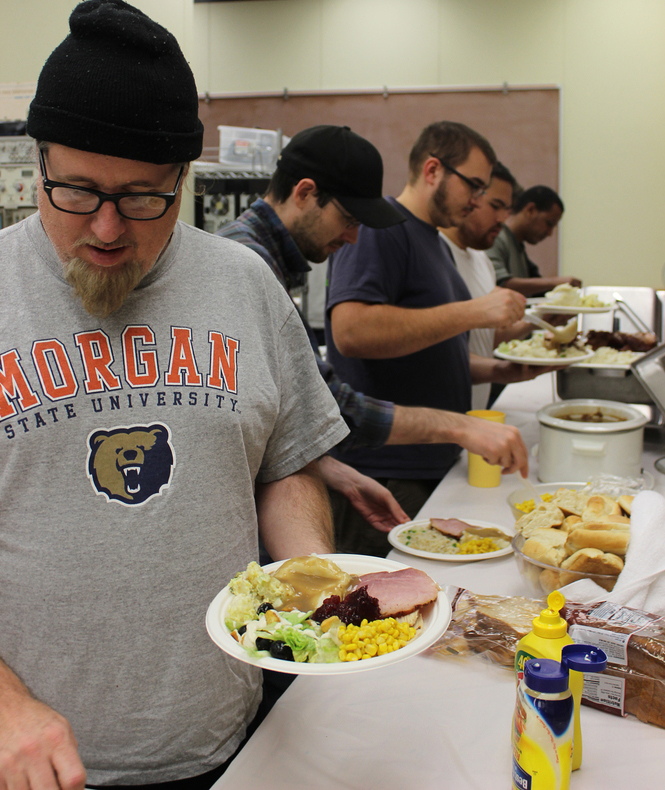 PICTURE OF THE DAY-Nov. 21, 2012.  Pierre Petuya, the president of Electronic Student Association at City College, grabs a plate of food during their annual Thanksgiving potluck. Tony Wallin | wallintony@yahoo.com