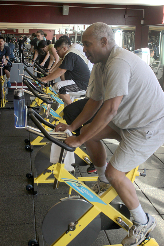 Male and female students work out in the City College gym.
