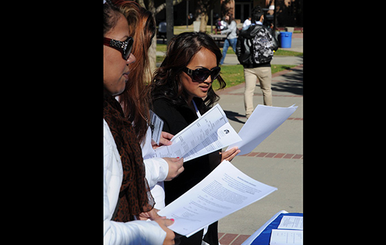 Cosmetology student Phiv Tan, far right, looks over job announcements on February 11 at the City College quad, regarding job openings at the Sacramento Childrens Home. | Rafael Baez | rebaez@sbcglobal.net