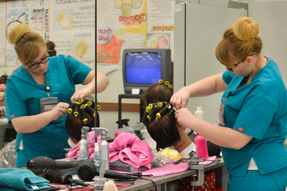 City College cosmetology major Natalie Rotaru practices mastering the curl technique inside the cosmetology center Feb 26. She hopes to succeed and complete her project.   Emily Foley | Staff Photographer | emmajfoley@gmail.com