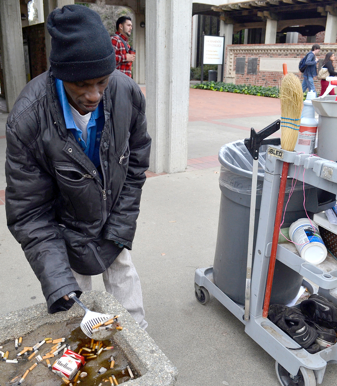 Part-time City College custodian, Kelvin Martin scoops cigarette butts from an ash tray Feb. 18 in the Quad. Martin, a liberal studies major, will empty all the containers on campus during his workday.Elizabeth Ramirez | staff photographer | elizabethramirezexpress@gmail.com