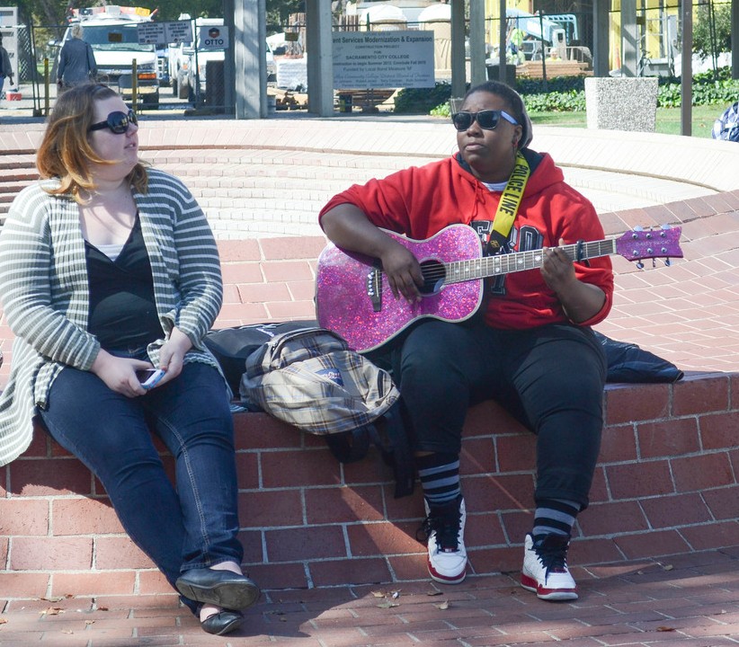 City College nursing program major Elonda Wright (right) and criminal justice major Rachael Harmon find the sunshine and breeze perfect weather for a chill jam session outdoors March 6 by the fountain. Photo by Gabrielle Smith| Staff Photographer | gsmith.express@gmail.com