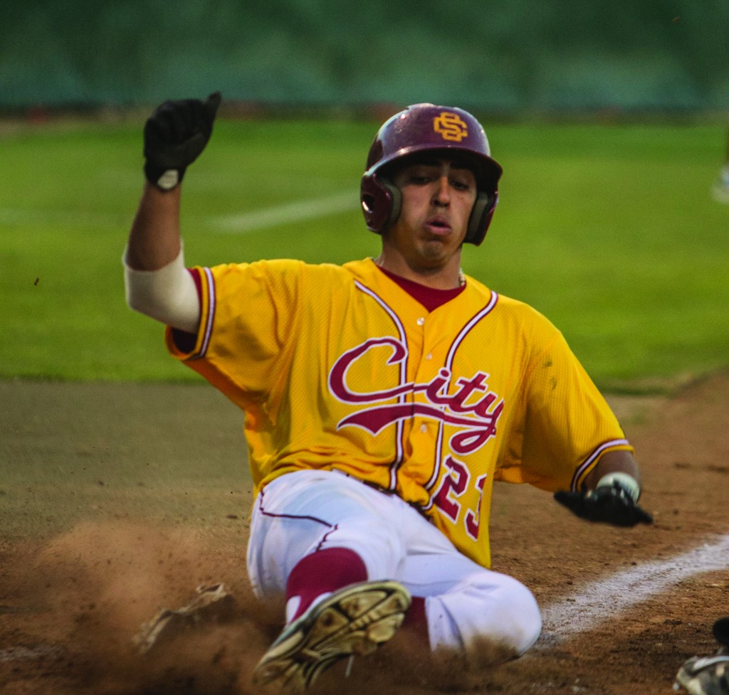 City College freshman outfielder Cristain Bracero slides in to home plate during a Panthers home game at Union Stadium.