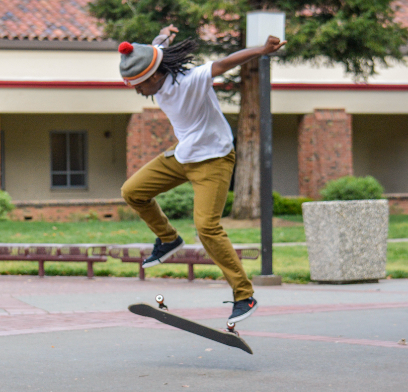 Graphic design major Malcolm Moore attempts to land his skateboard while outside the Preforming Arts Center April 2. Moore says his passion for skateboarding began in the eighth grade. | Emily Foley | Staff Photographer | emmajfoley@gmail.com