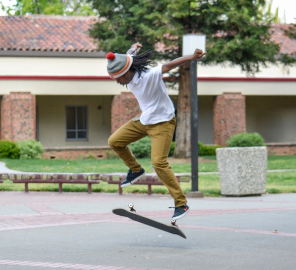 Graphic design major Malcolm Moore attempts to land his skateboard while outside the Preforming Arts Center April 2. Moore says his passion for skateboarding began in the eighth grade. Emily Foley | Staff Photographer | emmajfoley@gmail.com