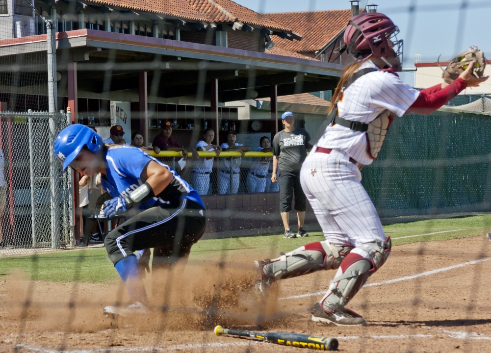 College of San Mateo scores April 11 when City Colleges catcher Allie Cheetham receives the softball too late to tag the teams runner out before sliding home. The Panthers were no match for the Bulldogs who defeated City College at The Yard with a final score of 11-1. Photo by Teri Barth | Online Editor in Chief | express.teri.barth@gmail.com