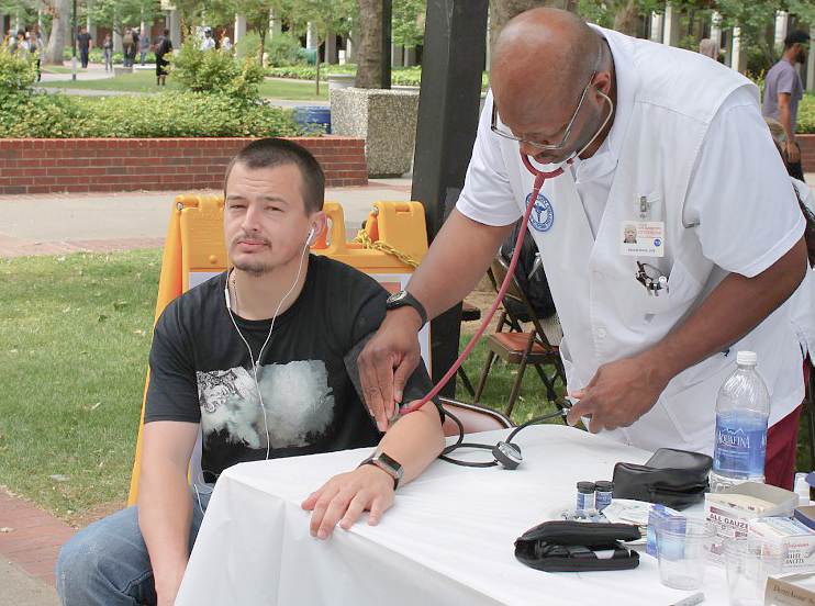 History major Casey Denicore (left) takes advantage of no-cost blood pressure testing offered during City Colleges health fair April 24 in the Quad. Photo by James Bergin | Staff Photographer