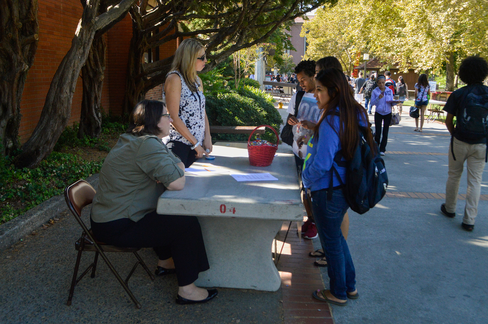 City College foundation workers, Ann Love (left) and Rachel Larsen (right),  converse with students about information regarding scholarship requirements outside of the City Cafe. Emily Foley | Staff Photogrpaher | emmajfoley@gmail.com