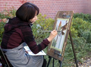 City College third year art major student, Deukjee Kim, likes to set up her painting station outdoors on campus to  create a painting of tress displaying fall colors.   <span id=
