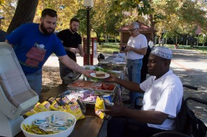 City College music student Silverboy Smith, in front and visitor, Fred Gonzalez get their lunch served by local veterans. | Staff Photograper | Emily Foley | <span id=