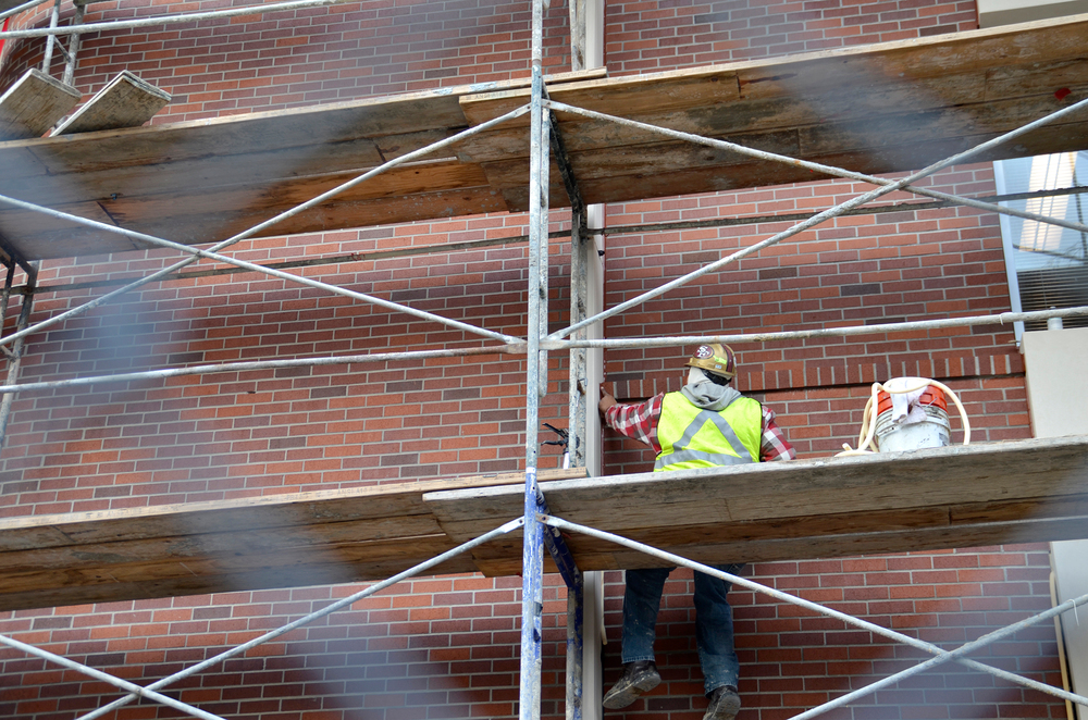 A construction worker removes silicon excess Jan. 26 from a pillar of the new building at City College. The building will house the journalism, photography depatments as well as student services. It is expected to be completed by mid- to late Spring 2015. Elizabeth Ramirez|Multimedia editor|elizabethramirezexpress@gmail.com