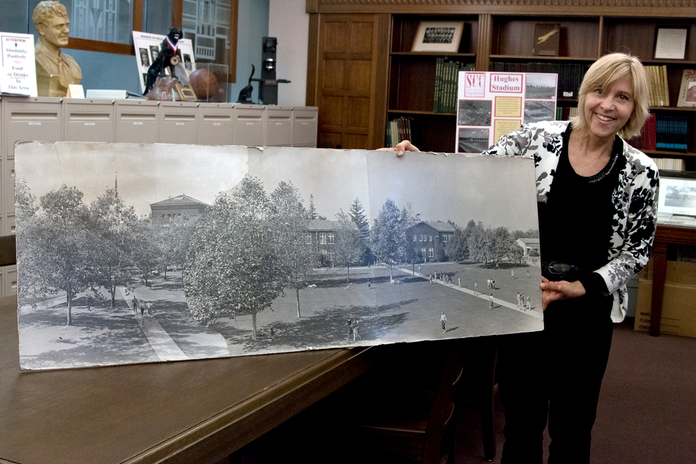 City College Special Collections Librarian Caroline Harker with an early photo of the campus. Photo by Penelope Kahn