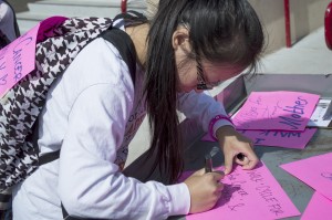 City College psychology student Maria Nguyen, creates a flyer before joining the annual cancer awareness walk around Hughs Stadium with other students and faculty March 19. Nguyen is one of 180 college students around the US participating in a national fundraiser. 4K for Cancer helps raise awareness to the Ulman Cancer Fund for young adults programs. Luisa Morco | Staff Photographer