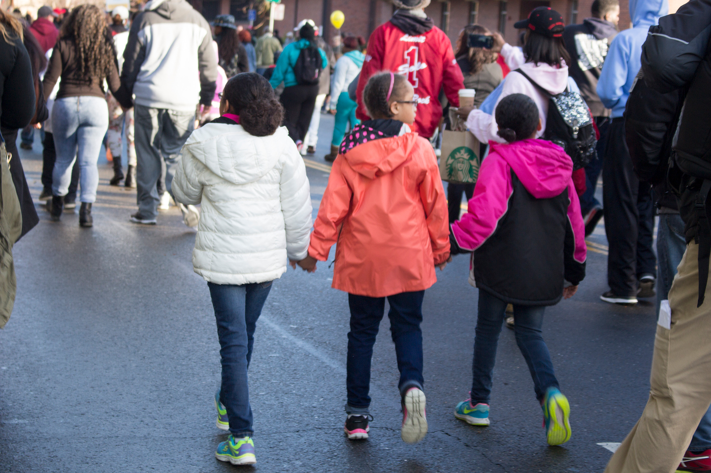 Three young girls walk while holding hands in the Martin Luther King March for the Dream. Photo by: Julie Jorgensen. juliejorgensenexpress@gmail.com