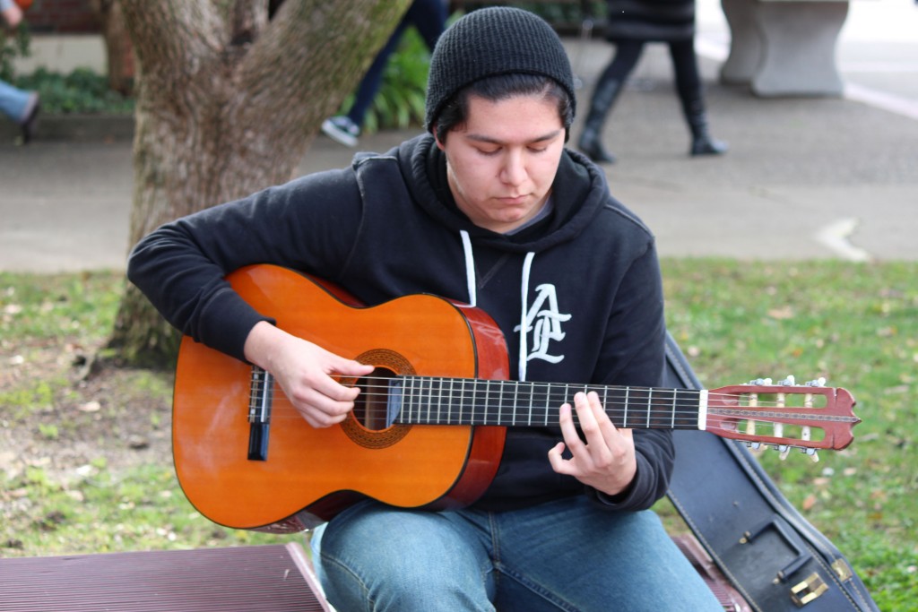 City College student Ivann Fernandez, Marine Biology major, taking a break between his classes to play his guitar in the courtyard on Wednesday, January 20, 2016. 