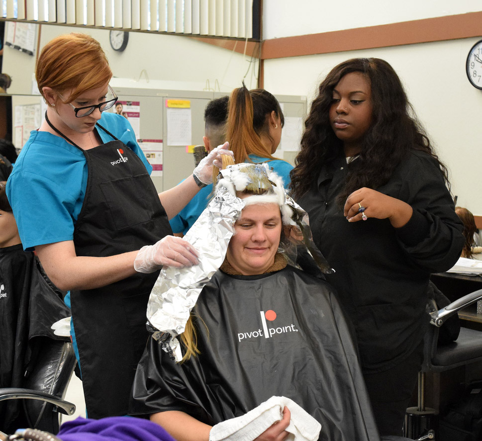 
City College cosmetology students Beth Treat (left) and Kambreeona Mayhand color the hair of client Melissa White in the cosmetology building on Thursday. Treat and Mayhand are working towards their cosmetology certificates.  Genoira Lundy, Staff Photographer. | genoiralundyexpress@gmail.com

