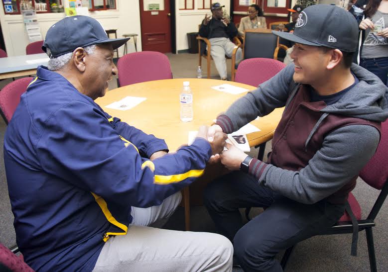 Former National Negro Baseball League player Dennis Biddle signs his baseball card for City College student Eric Dipad, occupational therapy major. Biddle was the youngest person to play in the National Negro Baseball League. Feb. 11, 2016. Diane Mitchell, Guest Photographer.| 4jedimi@gmail.com