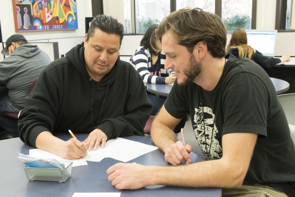 City College student Armando Vela, film major, receiving help from Nathaniel Meier, math tutor, with understanding difficult math problems. Genoria Lundy, Staff Photographer. | <span id=