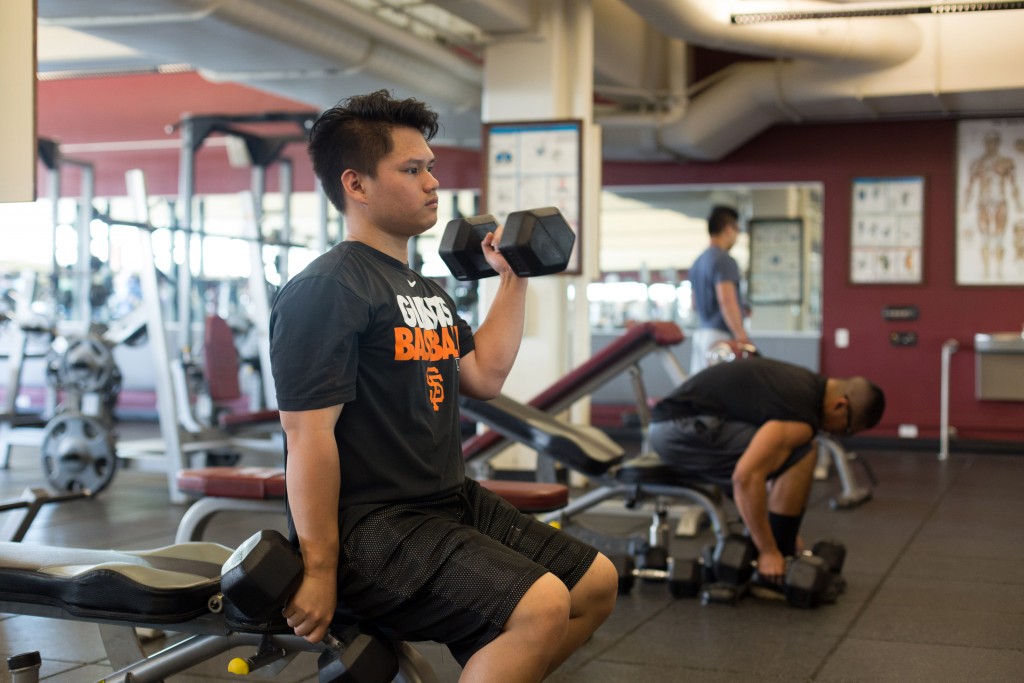City College student Vinnie Saechao, business major, doing bicep curls in the Life Fitness Center on March 28, 2016. Hector Flores, Staff Photographer. | hectorfloresexpress@gmail.com