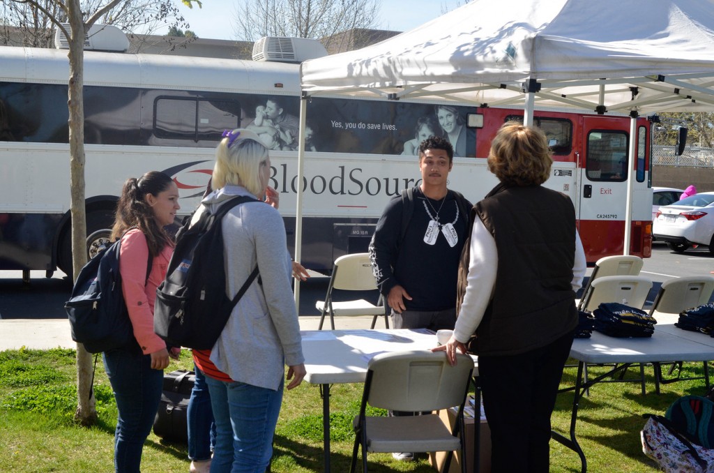 In front of the Blood Souce bus, students are talking to a Blood Souce volunteer about  the process to donate blood. March 15, 2016. Christopher Williams, Staff Photographer. |chrisWexpress@gmail.com