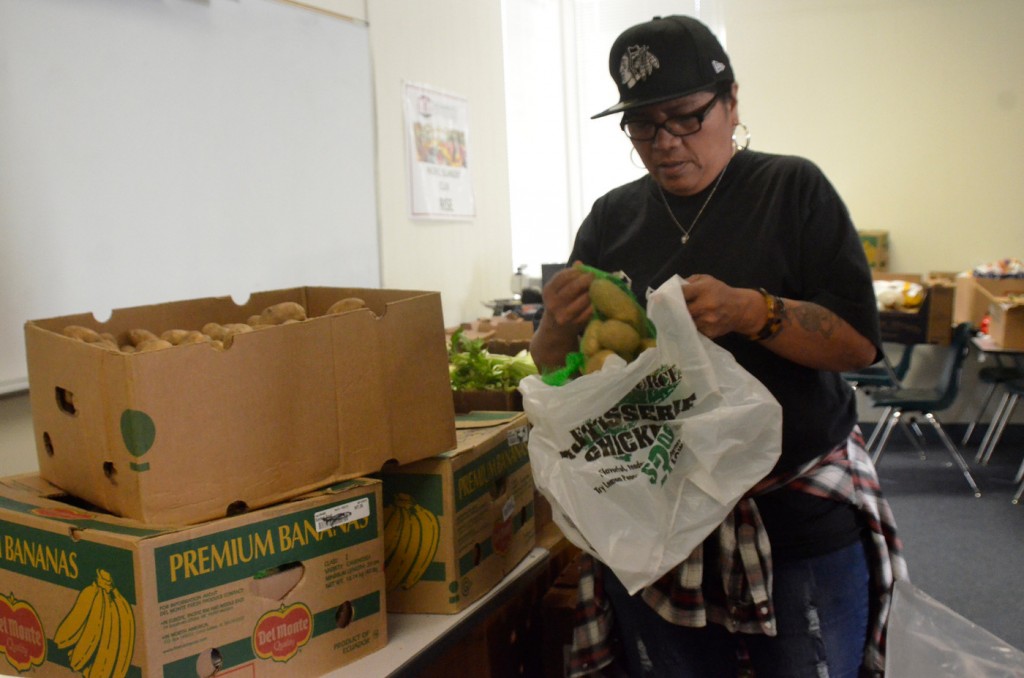 RISE staff member Nyla Vaivai is bagging potatoes for Candice Phillips, art major, as she is getting bags of food items that are offered as a part of the RISE weekly food distribution held at City College April 6, 2016. Barbara Williams, Staff Photographer. | BarbarajExpress@gmail.com