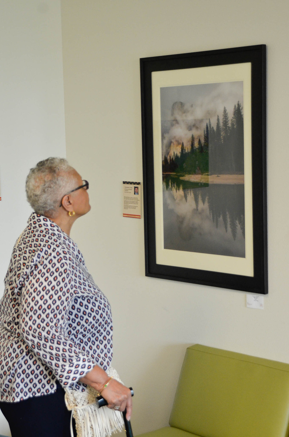 Pam Haynes, a Los Rios Board Trustee, is viewing a photo print titled "Clouded Reflections" by Chris Ring. This artwork is on display at the Veteran’s Art Show, on the third floor of the City College West Sacramento Center. April 9, 2016. Christopher Williams, Staff Photographer. |chrisWexpress@gmail.com