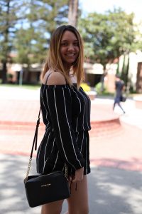 Emily Hevans, 18, majors in criminology and minors in psychology. She sports a cute, black off the shoulder single piece romper paired with a matching black Michael Kors purse. Despite her put-together look, Hevans says that she “saw it was warm out and just threw it on.” Ulysses Ruiz | Staff Photographer | Uruiz.express@gmail.com
