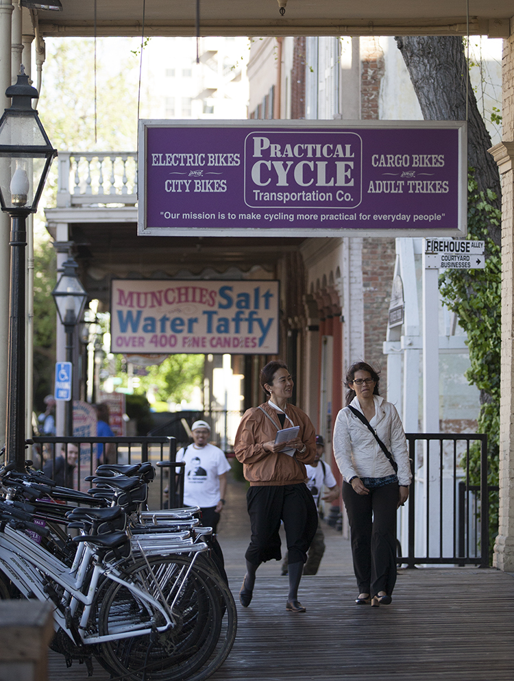 Visitors take in the sights of the storefronts in Old Sacramento in front of the Practical Cycle bike shop Friday, March 31, 2017. The shop has been open for seven years. Vanessa Nelson  | Photo Editor | vanessaneslonexpress@gmail.com