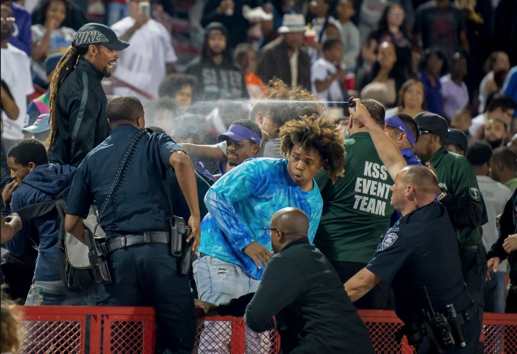 A Los Rios police officer pepper sprays the crowd at a high school football game after a fight broke out in the stands at Hughes Stadium, Friday, Sept. 15. | Photo by The Sacramento Bee | Brian Baer 