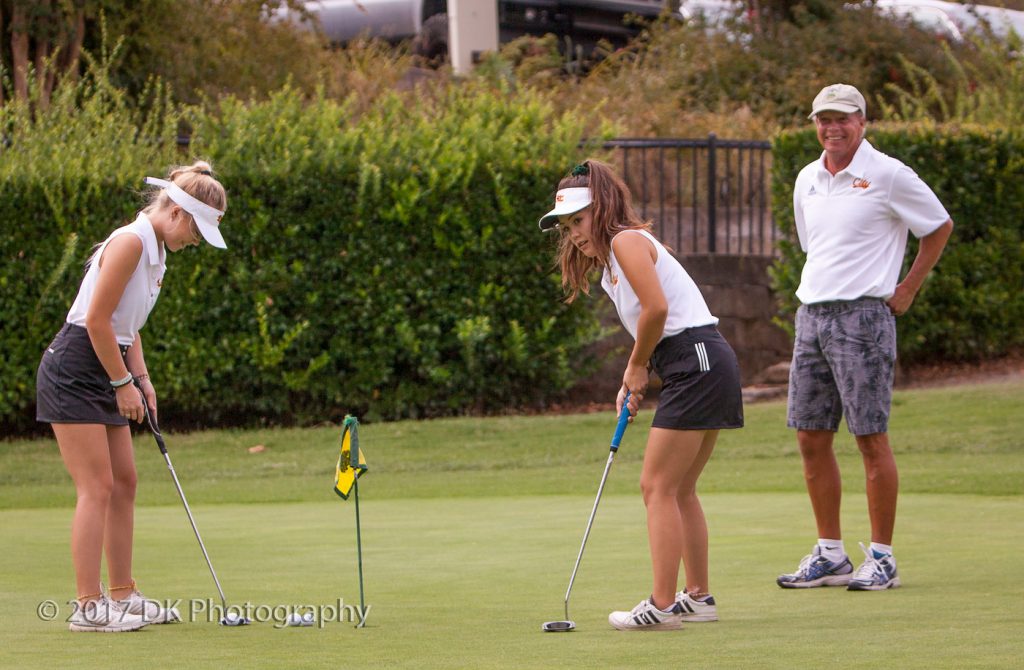 City College assistant coach John Hoag watches as sophomore sisters Hunter (left) and Ciera Hoag (right) practice putting before the Big 8 match at Whitney Oaks Golf Course on Sept. 7th. ©2017 Dianne Rose