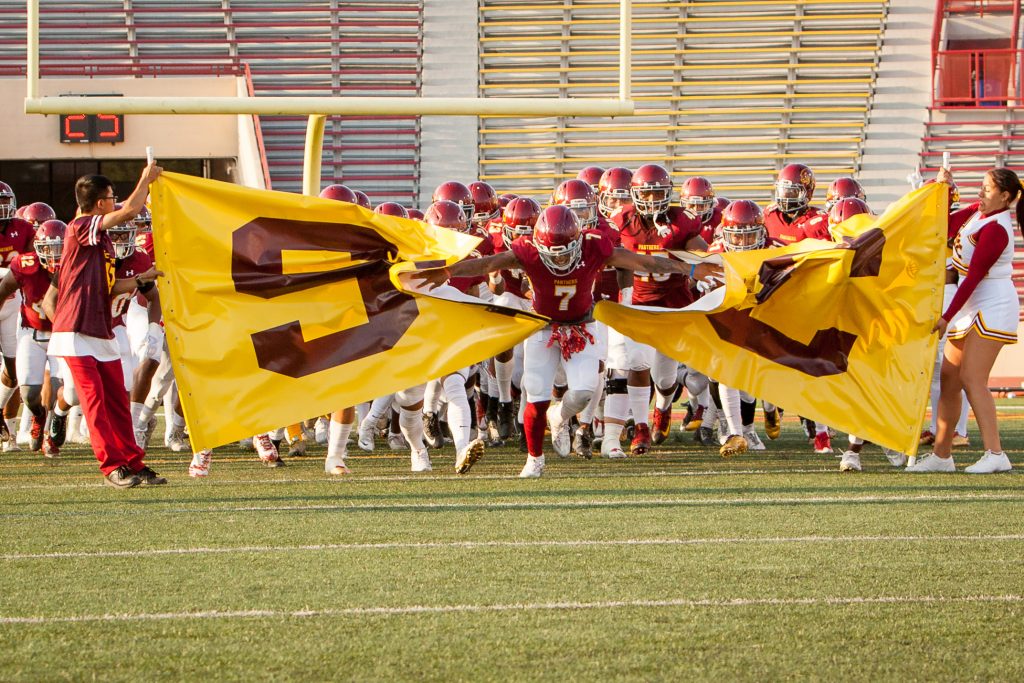 City College football team breaks through the SCC banner to start the game against Modesto Junior College at Hughes Stadium on Sept. 16. ©2017 Dianne Rose