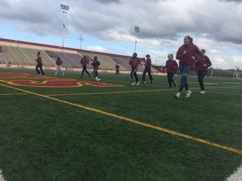 Members of the City College women's track and field team warm up for practice March 1 at Hughes Stadium. | Photo by Destinee Lang | dlang.express@gmail.com