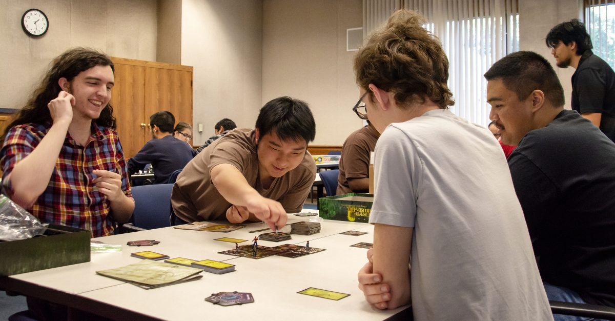 (from left to right) Josh Connor (mathematics major), Jarrod Lee (undecided), Anthony Martinez (nursing major) and Alvic Haban (communications major), playing “Betrayal at House on the Hill” at the International Games Day event in the Learning Resource Center Thursday. Sara Nevis | 1saranevis@gmail.com