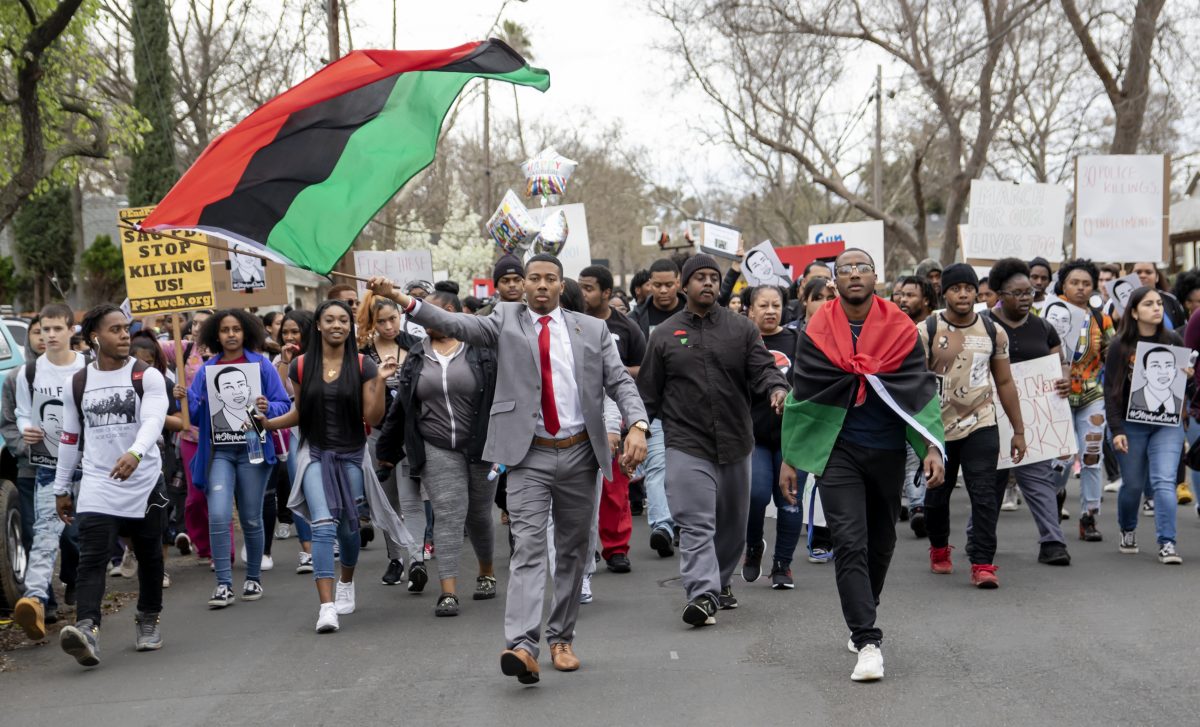 City Snapshot! Khalil Ferguson, Sacramento State international relations and economics major (waving Pan-African flag); Joshua Robinson, City College Black Student Union president and social science major (center); Jayshawn Yancey, Sac State child development major (Pan-African flag around his shoulders) and assorted student body during the March for Our Lives Too: Police Gun Reform, which started in the quad at City College, then to McClatchy High School, Sac High School and finally to the State Capitol Thursday March 7, 2019. Photo by Sara Nevis | Staff Photographer | snevis.express@gmail.com