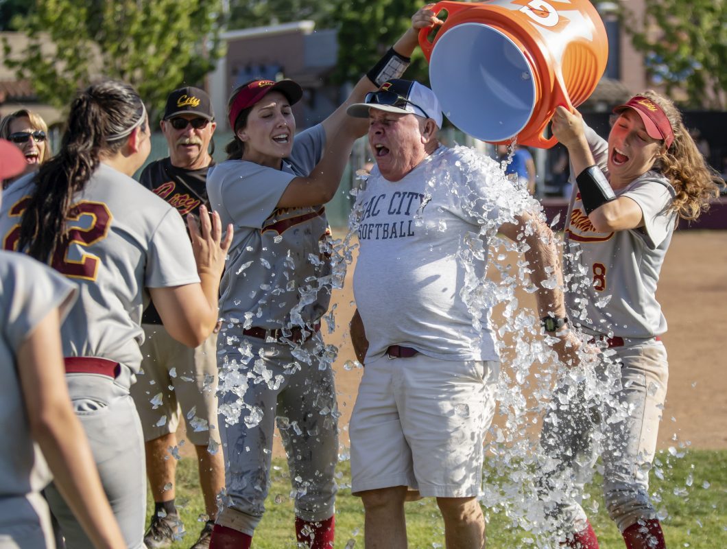 City College Morgan Conner (25) and Rylee Retzer (8) douse Head Coach Tim Kiernan after the win against Sierra College in game three of the NorCal Regional Playoffs round two at The Yard at City College May 11, 2019. City College beat Sierra College 8-6. Photo by Sara Nevis | snevis.express@gmail.com