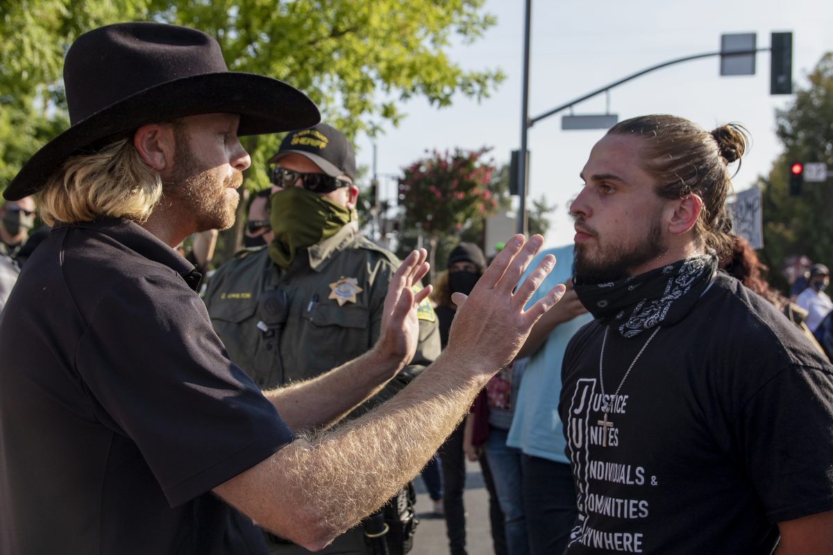 A counter protester has an interaction with a Juice member while a Sheriff watches during the Loomis Community BLM Rally at the intersection by Raley’s on Horseshoe Bar Road in Loomis, California, Saturday, July 25, 2020. Counter protesters were present chanting “all lives matter” and engaging with the BLM protesters. (Sara Nevis/snevis.express@gmail.com)
