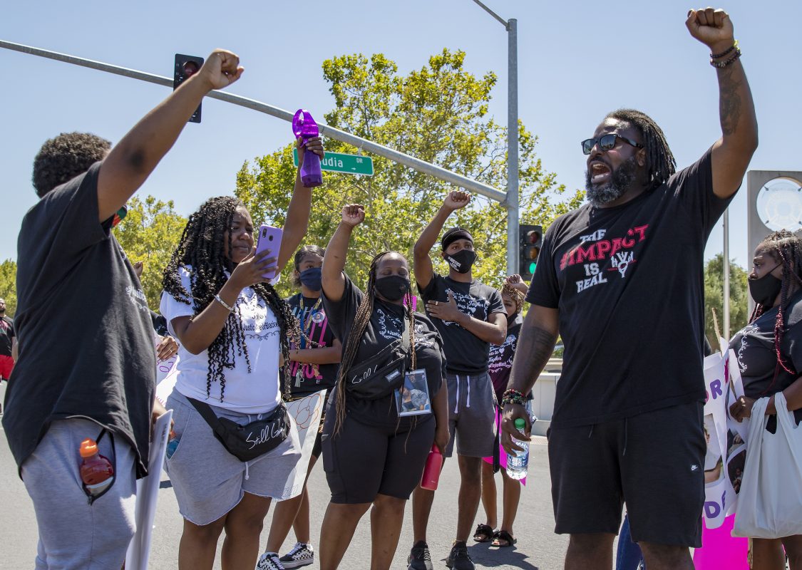Berry Accius, right, community activist and founder of Voice of the Youth, raises his fist while he speaks to the group gathered at the intersection of Freeport Boulevard and Claudia Drive at the Justice for Taylor Blackwell demonstration that started at Walgreens on Fruitridge Boulevard and marched to The Public Safety Center on Freeport Boulevard in Sacramento, California, Monday, July 13, 2020. Blackwell, 19, was found dead at WoodSpring Suites on La Mancha Way Feb. 28, 2020, in Sacramento. (Sara Nevis/snevis.express@gmail.com)