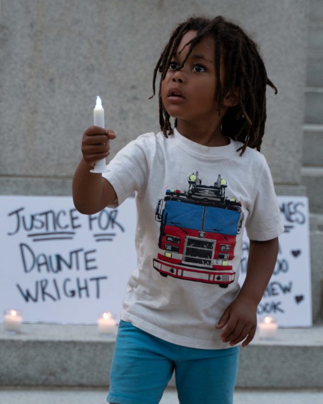 A child raises a battery-powered candle at a vigil hosted by Black Justice Sacramento and Anti Police-Terror Project. The candlelight vigil was held in honor of Daunte Wright, Adam Toledo, George Floyd and Matthew Zodok on Saturday, April 17 at Caesar Chavez Park in Sacramento. (photo: Diana Martonez/dmartinez.express@gmail.com)