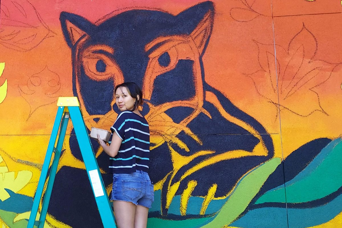 Student Brianna Wong paints City College’s Panther mascot on the backside of the Fischbacher Fine Arts Building on May 8, 2024.