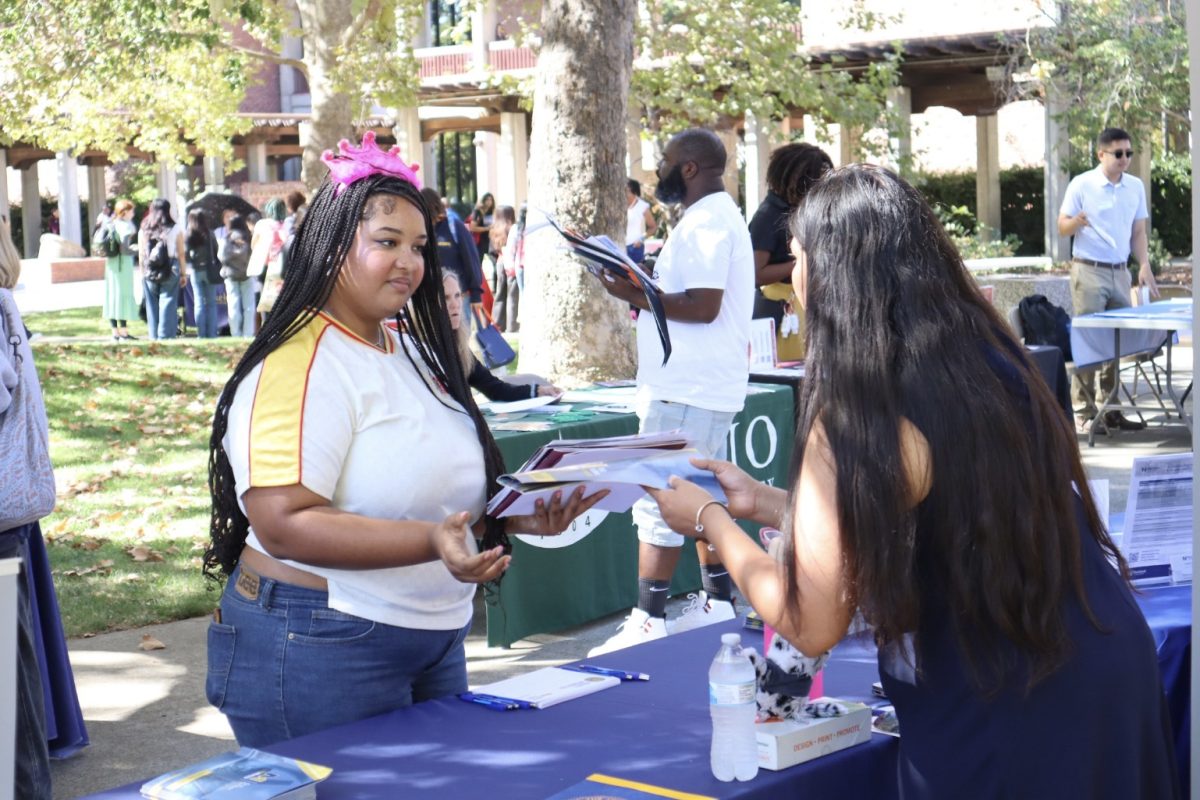 Chanel Brown (left) speaks with Alyssa Artegga, an admissions adviser for UC Merced during Sacramento City College’s Transfer Day on Sept. 26, 2024, on campus in Sacramento, Calif.