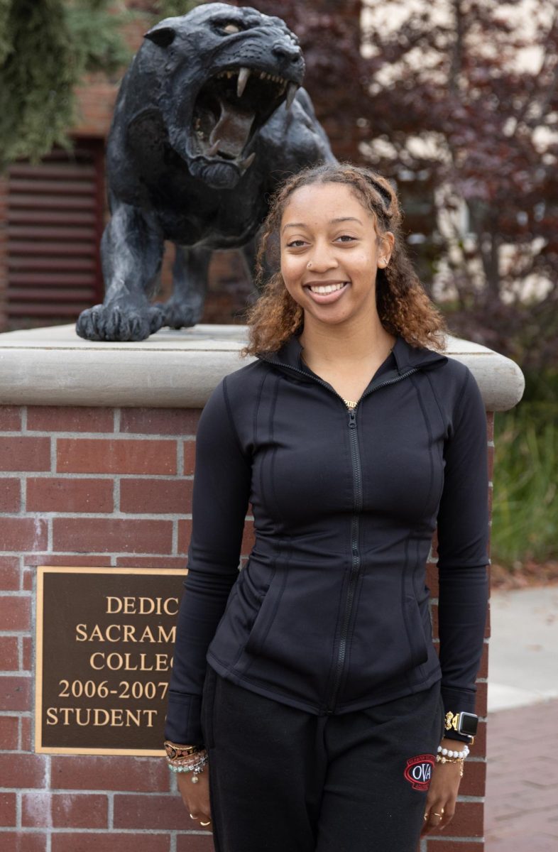 Volleyball player Myah Collier smiles in front of the Sacramento City College Panther statue on campus on Tuesday, Nov. 19, 2024 in Sacramento, Calif.